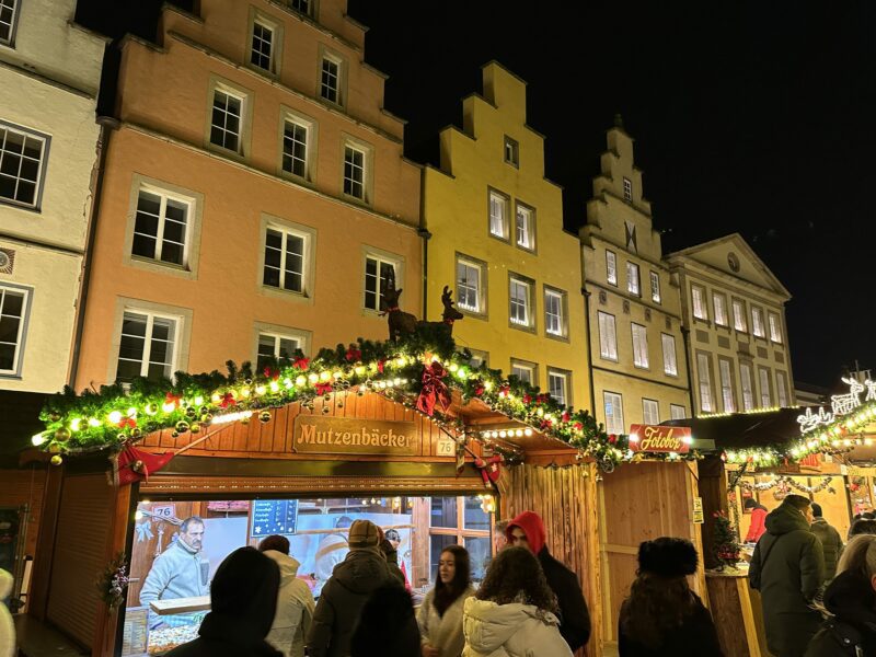 Mutzenbäcker vor den Giebelhäusern auf dem Weihnachtsmarkt.